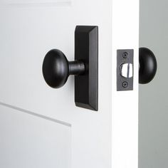 an open door with a black handle and knobs on it's front door