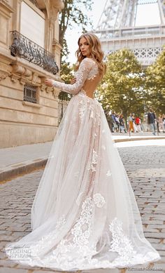 a woman in a wedding dress standing on the street