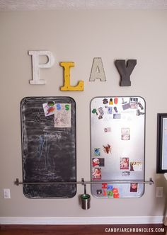 a refrigerator with magnets on the wall and letters above it that spell out play