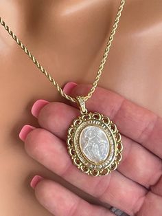 This is a beautiful extra large 18k gold filled Mary Miraculous pendant necklace for women.  This stunning pendant features the etched carving of mother of pearl shell surrounded with clear pave crystals. The lovely large cameo pendant comes on a beautiful 18k gold filled 2mm rope chain with spring clasp in back. Pendant measures 38x30mm and it is even more impressive in person!  Comes in a cute gift box! Luxury Gold Cameo Necklace, Gold Oval Mother Of Pearl Necklace, Gold Oval Necklace With Mother Of Pearl, Gold Intaglio Necklace, Oval Mother Of Pearl Gold Necklace, Luxury Carved Gold Necklace, Gold Carved Round Pendant Necklace, Luxury Gold Cameo Jewelry, Gold Medallion Necklace With Carved Details