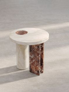 a marble table sitting on top of a cement floor next to a white and brown object