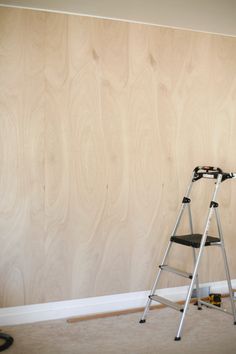 a ladder leaning up against a wall with wood paneling