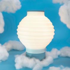 a white lamp sitting on top of a cloud filled blue sky with clouds in the background