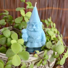 a blue gnome figurine sitting on top of a plant