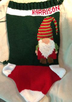 a knitted christmas stocking with a santa clause on it's bottom and the word harrison written in red