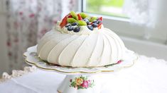 a cake with fruit on top is sitting on a plate