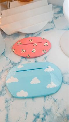 two wooden trays sitting on top of a marble counter covered in clouds and flowers