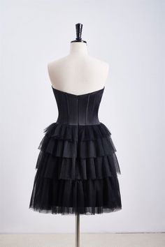 This dress features a corset bodice and a tiered ruffle skirt, with a sweetheart neck and zip-up back. Made from black tulle, it has an A-line silhouette and falls above the knee. Item #NP1112 Material: Tulle Color: Black Silhouette: A-line Embellishment: Corset bodice, tiered ruffle skirt Neck: Sweetheart neck Back: Zip-up Length: Above knee length Fully lined: Yes Built-in bra: Yes True to size. Made in China. Dresses are usually packed inside out for protection. Hand wash Formal Corset Dress With Sweetheart Neckline And Ruffles, Black Corset Dress With Ruched Bodice For Prom, Black Strapless Corset With Ruffles, Black Tulle Dress With Ruffles, Black Corset With Ruched Bodice For Evening, Fitted Tulle Corset Dress With Ruffles, Tiered Corset Dress With Ruffles For Party, Tiered Ruffle Corset Dress For Party, Black Sleeveless Corset With Ruched Bodice