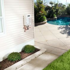 a house with a pool in the back yard and grass on the ground next to it