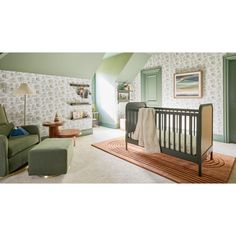 a baby's room with a green chair and wallpapered walls in the background