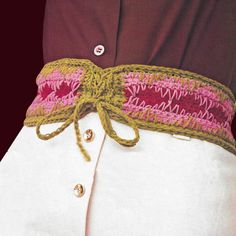 a close up of a person wearing a white shirt with a pink and green belt