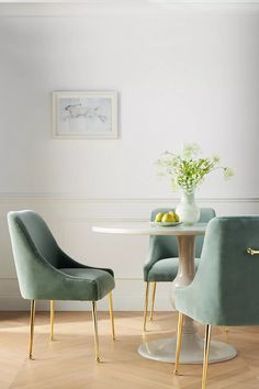 two chairs and a table in a room with white walls, wood floors and wooden flooring