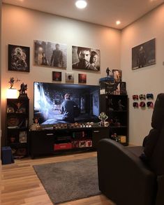 a living room filled with furniture and pictures on the wall above it's flat screen tv