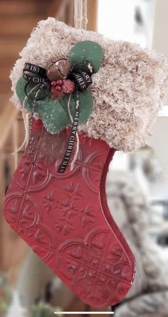 a christmas stocking hanging from the ceiling with decorations on it's side and an ornament in the center