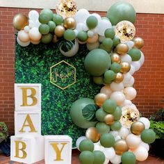 a baby shower is decorated with balloons and greenery