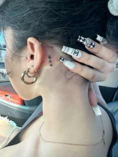 a woman with tattoos on her neck and behind her ear is sitting in a car