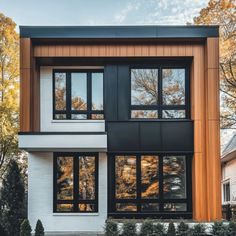 a modern house with black and white trim on the front, windows are open to let in natural light