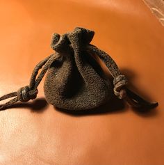 a small bag sitting on top of a brown leather couch next to an orange wall