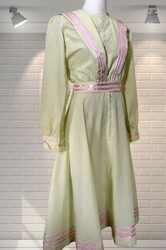 "This dress is incredible, beautiful and scarce.   By Roberta Vercellino; pieces are rare and very sought after. Edwardian style sailor collar fit and flare dress.  The fabric is pistachio green with pink ribbon trim.  The collar is embroidered and the bodice wraps over and fixes with press studs.  Two buttons at the waist and a central zipper. Overall this piece is in fabulous condition; there are some subtle issues so please view the photos.  Some light fading on the shoulders and a little on the sleeves (not immediately noticable), there are two faded marks - on one on the sleeve and one on the skirt and a small snag on the sleeve.  I have not attempted to clean the dress; it's as is. That aside, this is a stunning dress and Vercellino pieces are ultra rare and sought after.   It measur Fitted Pista Green Cotton Dress, Elegant Fitted Pista Green Dresses, Elegant Pista Green Long Sleeve Dress, Pista Green Long Sleeve Fitted Dress, Elegant Pista Green Spring Dress, Elegant Pista Green Dress For Spring, Retro Green Vintage Dress For Daywear, Vintage Light Green Dress For Spring, Green Lined Vintage Dress For Summer