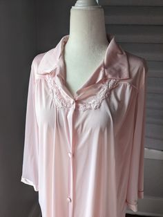 "Vintage Vanity Fair robe, could also be worn as a nightgown because it is so lightweight soft, lightweight nylon fabric with satiny finish on collar and at sleeve ends button down front with one side pocket The size tag is missing. I believe it is medium based on measurements: 22\" across front between armpits, 41\" long. I am a size 12 and tried it on. While it does fit me, robes should be loose. The mannequin is a size 6 small and it is just a tad big on it." Summer Long Sleeve Nightgown For Overnight, Long Sleeve Summer Nightgown, Spring Long Sleeve Nightgown, Spring Overnight Robe With Long Sleeves, Spring Overnight Long Sleeve Robe, Feminine Long Sleeve Robe For Daywear, Spring Long Sleeve Chemise For Bedtime, Long Sleeve Spring Chemise For Bedtime, Satin Long Sleeve Nightgown For Loungewear