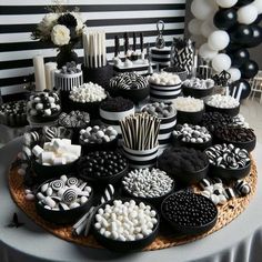 a table topped with lots of black and white desserts