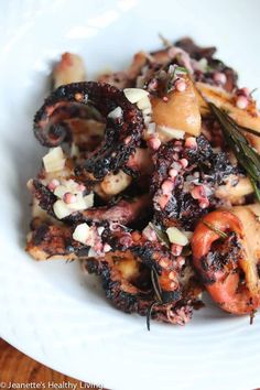 a white plate topped with octopus and vegetables