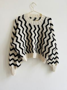 a black and white sweater hanging on a wall