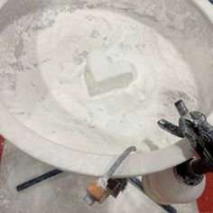 a bucket filled with white powder and some tools