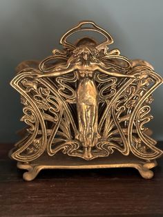 a gold colored statue on top of a wooden table