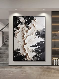 an abstract painting hangs on the wall next to a staircase in a modern living room