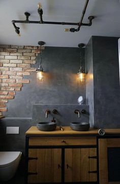 a bathroom with two sinks and some lights on the wall above it's counter