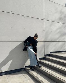 a person leaning against a wall with their hand on the back of an umbrella bag