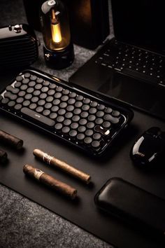 an assortment of different types of cigars on a table next to a laptop computer