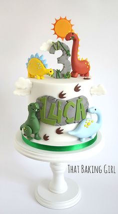 a birthday cake decorated with dinosaurs and letters