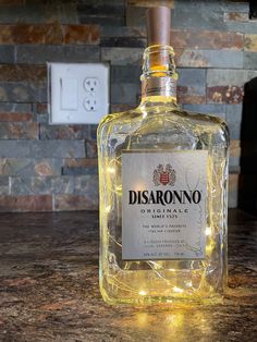 a bottle of disaronono is sitting on a counter with some lights around it