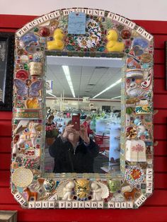 a woman taking a selfie in front of a mirror with many different things on it