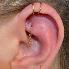 a woman's ear with two gold chains attached to it