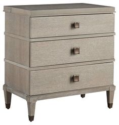 a white dresser with three drawers and two handles on each drawer, against a white background