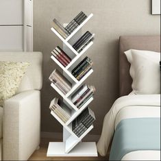 a white book shelf sitting next to a bed