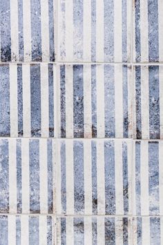 a tile wall with blue and white stripes on it