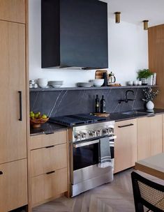 a kitchen with wooden cabinets and black counter tops, stainless steel appliances and an oven