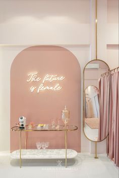 the interior of a store with pink walls and gold accents, including a vanity table