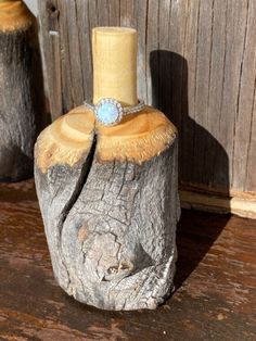 a ring sits on top of a piece of wood that has been carved into it