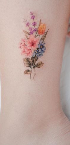 a woman's lower back tattoo with flowers on her stomach and the bottom part of her body