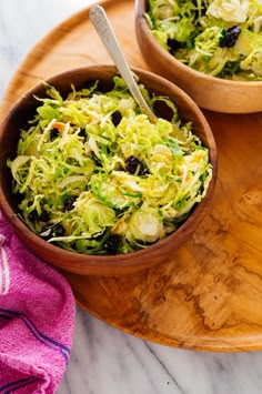 two wooden bowls filled with salad on top of a table