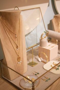 a display case filled with lots of jewelry on top of a wooden table next to other items