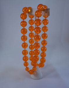 "Vintage c1950's tangerine orange clear lucite bead necklace Excellent condition 1/2\" diameter bead, except for the bead adjacent to the clasp bead, those are 3/8\" diameter and 1/4\" diameter The clasp bead is 1/2\" 26 inches long" Orange Round Faceted Beads Jewelry, Vintage Orange Beaded Necklaces For Formal Occasions, Orange Hand-strung Jewelry With Round Beads, Orange Single Strand Beaded Necklace, Orange Single Strand Beaded Necklace With Round Beads, Vintage Orange Jewelry With Faceted Beads, Orange Vintage Jewelry With Faceted Beads, Formal Orange Single Strand Necklace, Vintage Orange Round Beads Necklace