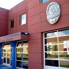 the outside of a building that is red with blue trim and windows on both sides