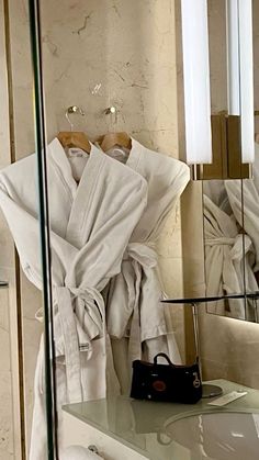 a robe is hanging on the wall next to a mirror