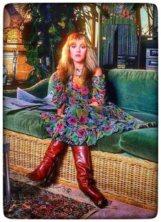 a woman sitting on top of a couch wearing boots